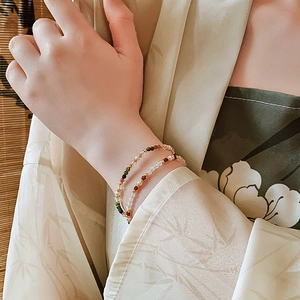 Detail of 18K gold-plated double-layer bracelet with colorful gemstones and pearls