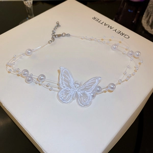Détail du collier papillon en organza multicouche avec broderie et perles d'imitation