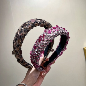 Close-up of thick tweed padded headbands in dark and pink sequins knit texture