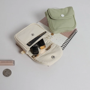 Detailed interior of mini canvas pouch with snap closure showing card slots and storage space