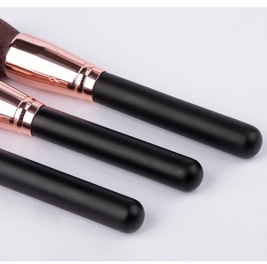 Detail view of dense brown synthetic bristles with rose gold ferrules and matte black handles