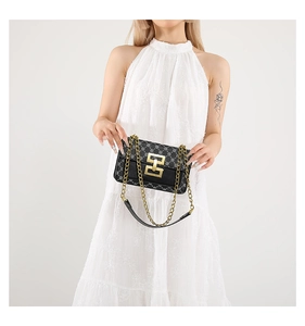 Détail du sac bandoulière à fleurs rétro avec boucle en métal doré sur robe en dentelle