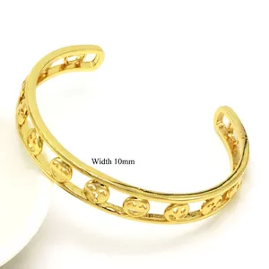 Detail view of gold chunky chain bracelet showing 10mm width and hollow smiley face motifs