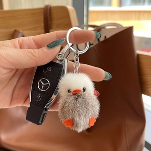 Plush grey-white duck keychain with orange beak on car keys