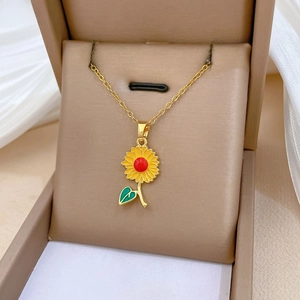 Détail du collier pendentif tournesol en émail avec centre rouge sur boîte à bijoux