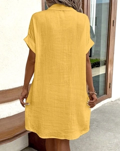 Rear view of loose yellow muslin shirt dress showing fabric texture and back neckline
