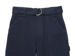 Dettaglio dei pantaloni blu scuro con cintura coordinata e fibbia a D in argento