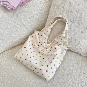 Gros plan sur les pois colorés et l'étiquette logo du sac fourre-tout en toile blanc