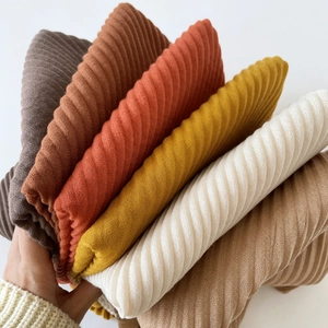 Close-up of pleated cotton-linen scarves in brown, mustard yellow and neutral tones
