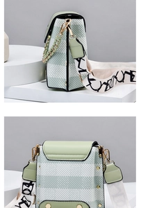 Detail of mint green crossbody bag with woven texture and wide graffiti strap