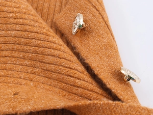 Dettaglio maglione in maglia a coste cammello con bottoni dorati vintage sulla spalla