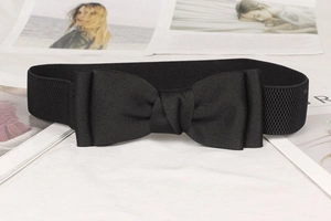 Detail of a black elastic waist belt featuring a large decorative bow and textured knit
