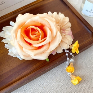 Détail macro d'une épingle à cheveux rose soie pêche avec un élégant gland de fleurs de perles