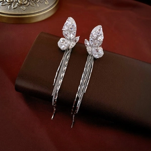 Vue détaillée des boucles d'oreilles papillon argentées avec pampilles sur cuir