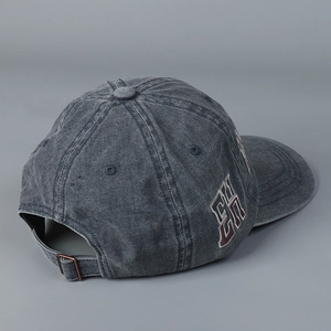 Detailed view of washed denim baseball cap with side embroidery and metal buckle