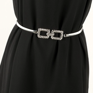 Close-up of golden elastic spring metal belt with interlocking textured rectangular buckles