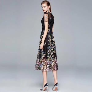 Elegant black high-waisted midi dress with colorful floral embroidery and slimming cut
