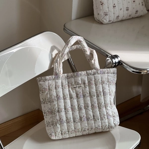 Detail of quilted cotton tote bag with rabbit floral pattern and simple wish woven label