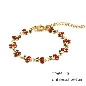 Bohemian 14K gold plated bracelet with sparkling red cherry pendants on white background