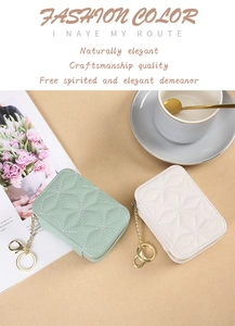 Detail of quilted mini lipstick pouches in mint green and cream with gold chain keyrings