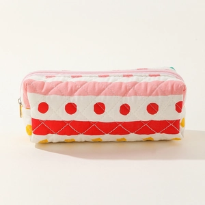 Close-up of quilted floral cotton fabric texture and colorful striped patterns on a makeup bag