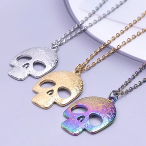 Detailed view of skull pendants with floral carvings in silver, gold, and rainbow finishes