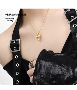 Close-up of gold irregular lava pendant necklace with textured surface worn by a model