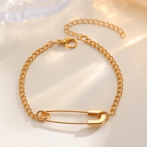 Detailed macro view of the gold safety pin pendant with chain and extension links