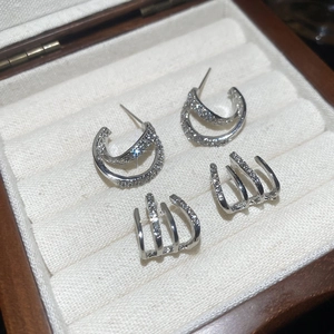 Macro shot of double-layered C-shaped silver earrings with sparkling cubic zirconia