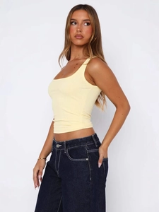 Slim fit yellow ribbed camisole top for women paired with dark denim jeans
