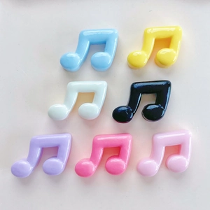 Flat lay of colorful musical note resin charms in seven vibrant glossy finishes for DIY