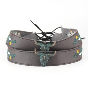 Detail of bohemian leather choker with embroidered flowers and bronze bull head pendant