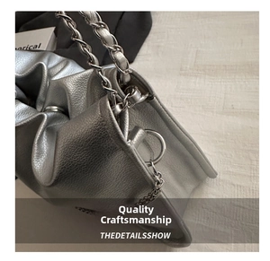Close-up of metallic silver bucket bag showing lychee leather texture and metal chain