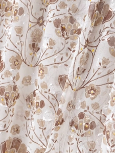 Macro view of sheer chiffon fabric with beige floral print and jacquard texture