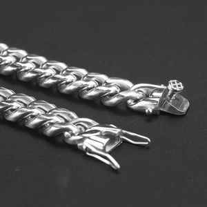 Macro shot of silver Cuban link chain detail showing metallic texture and buckle