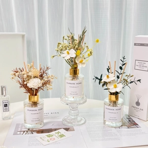 Three 120ml reed diffuser bottles with handmade white flowers and natural dried leaves