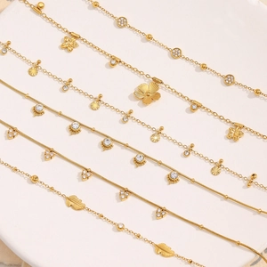 Detailed flat lay of 18K gold plated stainless steel necklaces with clover and leaf charms