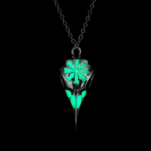 Luminous viking raven skull necklace showing bright green glow effect in the dark