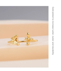 Detail of gold plated adjustable open ring featuring butterfly and bee insect motifs