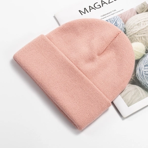 Detailed close-up of pink knitted beanie texture with a lifestyle magazine backdrop