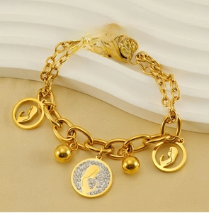 Macro view of gold stainless steel bracelet with hollowed Virgin Mary pendants and crystals