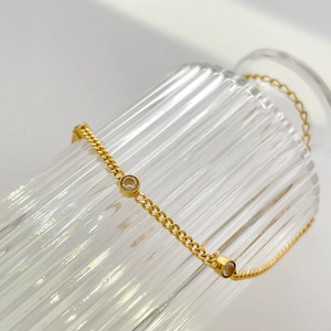 Detail of elegant gold snake chain bracelet with three sparkling round zircon stones