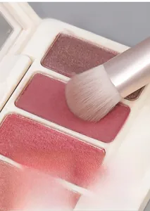Macro view of detailed makeup brush head picking up pigmented eyeshadow from a colorful palette