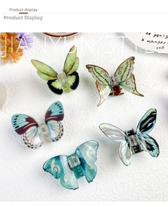 Five butterfly hair claws in various colors displayed on a white textured background