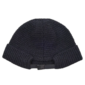 Detail of black knitted miki hat featuring adjustable buckle strap and ribbed texture