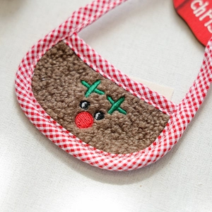Detailed close-up of reindeer embroidery on soft sherpa pet bandana with festive plaid trim