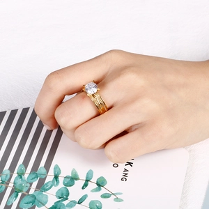 Detailed side view of a gold-plated titanium steel ring with a round zircon on finger