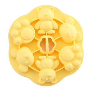 Yellow silicone steam mold with teddy bear and paw prints for baby food baking