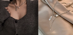 Detailed close-up of a silver toggle necklace with a pearl pendant and rectangular tag