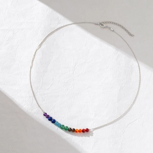 Detail of thin silver chain necklace with eleven vibrant rainbow crystal beads and lobster clasp